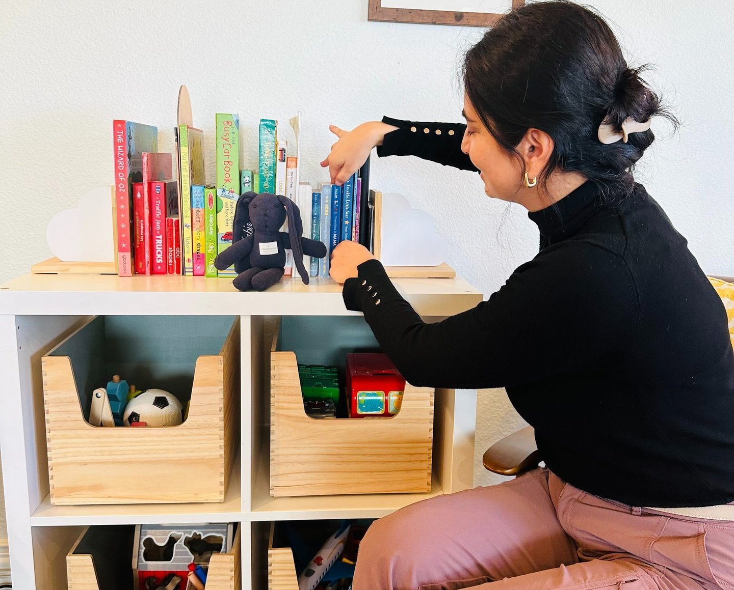 Professional organizer styling shelves in a tidy family space.